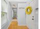 Bright hallway featuring hardwood floors, a decorative wreath, and natural light from a window at 5989 Turfway Park Ct, Sugar Hill, GA 30518