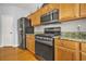 Kitchen featuring stainless appliances, wood cabinets, and granite countertops with tile backsplash at 5989 Turfway Park Ct, Sugar Hill, GA 30518
