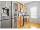 Open kitchen showcasing stainless steel appliances, wood cabinets, and hardwood floors at 5989 Turfway Park Ct, Sugar Hill, GA 30518