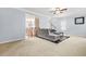 Open-concept living room featuring neutral color palette, plush sofa, and staircase access at 5989 Turfway Park Ct, Sugar Hill, GA 30518