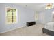 Well-lit bedroom with neutral walls, carpet, ceiling fan, and a gray upholstered bed frame at 5989 Turfway Park Ct, Sugar Hill, GA 30518