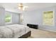 Well-lit bedroom with neutral walls, carpet, ceiling fan, and a gray upholstered bed frame at 5989 Turfway Park Ct, Sugar Hill, GA 30518
