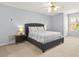 Well-lit bedroom with neutral walls, carpet, ceiling fan, and a gray upholstered bed frame at 5989 Turfway Park Ct, Sugar Hill, GA 30518