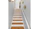 Bright stairway featuring hardwood steps, white risers, and a matching white railing at 5989 Turfway Park Ct, Sugar Hill, GA 30518