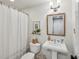 A simple half bath with a pedestal sink, mirror and tiled shower at 735 Longwood Nw Dr, Atlanta, GA 30305