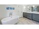 Luxurious bathroom with a freestanding tub, double vanity with marble counters, and stylish gray cabinetry at 735 Longwood Nw Dr, Atlanta, GA 30305