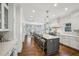 Bright kitchen featuring a large island with seating, white cabinets, and hardwood floors at 735 Longwood Nw Dr, Atlanta, GA 30305