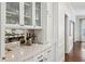 Elegant wet bar featuring glass front cabinets, quartz countertops, and designer fixtures at 735 Longwood Nw Dr, Atlanta, GA 30305
