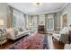 Sunlit living room featuring a patterned rug, stylish furniture, and large windows with plantation shutters at 735 Longwood Nw Dr, Atlanta, GA 30305