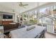 Screened-in porch featuring a dining table, wicker sofa, ceiling fan, and wooded view at 735 Longwood Nw Dr, Atlanta, GA 30305