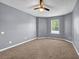 Large bedroom with neutral carpet, a ceiling fan, and a bright window at 2505 Tiffany Se Ct, Conyers, GA 30013