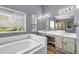 This bright main bathroom boasts double sinks, a soaking tub and glass shower at 2505 Tiffany Se Ct, Conyers, GA 30013