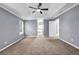 This main bedroom features plush carpet, a ceiling fan, natural light, and ample space at 2505 Tiffany Se Ct, Conyers, GA 30013