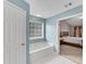 Bright bathroom boasts a soaking tub and an entrance to the main bedroom at 3925 Tugaloo River Dr, Duluth, GA 30097