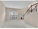 Bright living room featuring neutral walls, carpet flooring, and a staircase with a white baluster at 3925 Tugaloo River Dr, Duluth, GA 30097