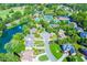 Aerial view of a neighborhood with a lake, community pool, tennis courts, and clubhouse surrounded by lush trees at 5675 Habersham Vly, Suwanee, GA 30024
