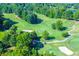 Aerial view of a well-maintained golf course with lush green fairways and trees on a sunny day at 5675 Habersham Vly, Suwanee, GA 30024