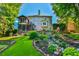 Stunning back exterior of a home featuring a screened porch, bay window, and tiered yard with a rock waterfall at 5675 Habersham Vly, Suwanee, GA 30024