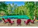 Gorgeous lake view with red Adirondack chairs on a gravel shoreline, surrounded by lush green trees, perfect for relaxation at 5675 Habersham Vly, Suwanee, GA 30024