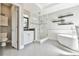 Bright and airy bathroom featuring a glass shower, freestanding tub and wall-mounted shelves at 5675 Habersham Vly, Suwanee, GA 30024