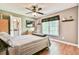 Cozy bedroom featuring a ceiling fan, wood floors, and a large window for natural light at 5675 Habersham Vly, Suwanee, GA 30024