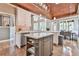 Gourmet kitchen with a center island, white cabinetry, stainless steel appliances, and wood-paneled vaulted ceiling at 5675 Habersham Vly, Suwanee, GA 30024