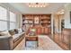 Cozy den with custom bookshelves, hardwood floors, a comfortable sofa, and a decorative rug at 5675 Habersham Vly, Suwanee, GA 30024