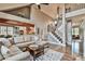 Spacious living room with hardwood floors, coffered ceiling, stone fireplace, and elegant staircase at 5675 Habersham Vly, Suwanee, GA 30024