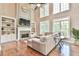 Inviting living room with fireplace, built-in bookshelves, large windows, and hardwood floors at 5675 Habersham Vly, Suwanee, GA 30024