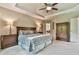 Spacious primary bedroom with tray ceilings, plush carpet, and an antique wardrobe at 5675 Habersham Vly, Suwanee, GA 30024