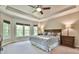 Serene bedroom with tray ceiling, plush carpeting, large windows, and stylish furnishings at 5675 Habersham Vly, Suwanee, GA 30024