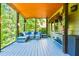 Relax on this covered porch with comfortable seating, wood flooring, and natural light at 5675 Habersham Vly, Suwanee, GA 30024
