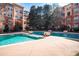 A spacious pool featuring a shallow lounging area, surrounded by trees and community buildings in the background at 10 Perimeter Summit Ne Blvd # 4315, Brookhaven, GA 30319