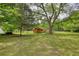 Large, well-maintained backyard with green grass and a quaint outbuilding at 123 Nelson Street, Newborn, GA 30056