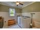 Well-lit laundry room with modern appliances, storage cabinets, and patterned flooring at 123 Nelson Street, Newborn, GA 30056