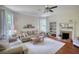 Bright living room featuring hardwood floors, fireplace with mantel, and large windows with decorative curtains at 123 Nelson Street, Newborn, GA 30056