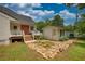 Outbuilding and porch create a welcoming entrance with stone pathway and vibrant garden at 123 Nelson Street, Newborn, GA 30056
