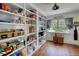 Well-stocked pantry with floor-to-ceiling shelving and abundant natural light from a window at 123 Nelson Street, Newborn, GA 30056