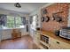 Open pantry with window, brick wall, and hanging pot display adding character at 123 Nelson Street, Newborn, GA 30056