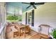 Inviting outdoor porch with dining table, ceiling fan, and painted ceiling perfect for relaxing and entertaining at 123 Nelson Street, Newborn, GA 30056