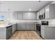 Kitchen featuring stainless appliances, gray cabinets, gray countertops and a view to a grassy backyard at 1707 Bouquet Way, Mcdonough, GA 30253