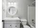 Bright bathroom featuring vanity with round mirror, white finishes, and combined shower and bathtub at 216 Buckland Dr, Alpharetta, GA 30022