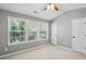 This bedroom is painted in light neutral colors and has three large windows for ample light at 216 Buckland Dr, Alpharetta, GA 30022