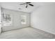 Spacious bedroom with ceiling fan, gray carpet, and natural light from two windows at 216 Buckland Dr, Alpharetta, GA 30022