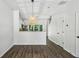 Open dining area featuring hardwood floors, a modern pendant light, and views of a bright, minimalist kitchen at 216 Buckland Dr, Alpharetta, GA 30022