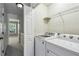 Hallway view of laundry room with shelving and white washer and dryer at 216 Buckland Dr, Alpharetta, GA 30022