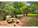 Beautiful backyard featuring a stone bench and patio area surrounded by mature trees at 3142 Chamblee Gap Rd, Cumming, GA 30040