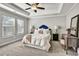 Bedroom with a tray ceiling, a ceiling fan, three windows, and plush carpeting at 5293 Hearthstone St, Stone Mountain, GA 30083