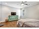 Bright bedroom featuring a ceiling fan, hardwood floors, and a modern turquoise credenza at 5293 Hearthstone St, Stone Mountain, GA 30083