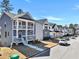Street view featuring elegant two-story homes with covered front porches and neat landscaping at 5293 Hearthstone St, Stone Mountain, GA 30083